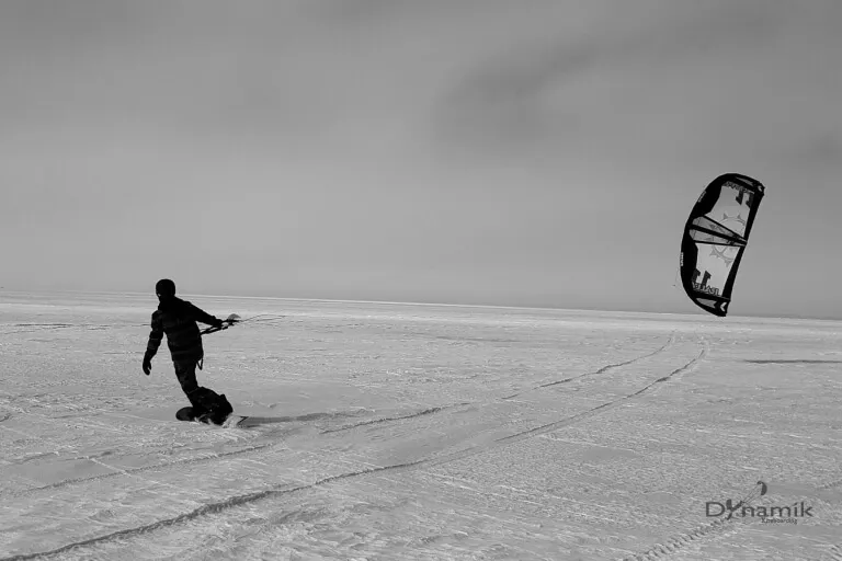 A kiteboarder gliding across a frozen lake in Minnesota